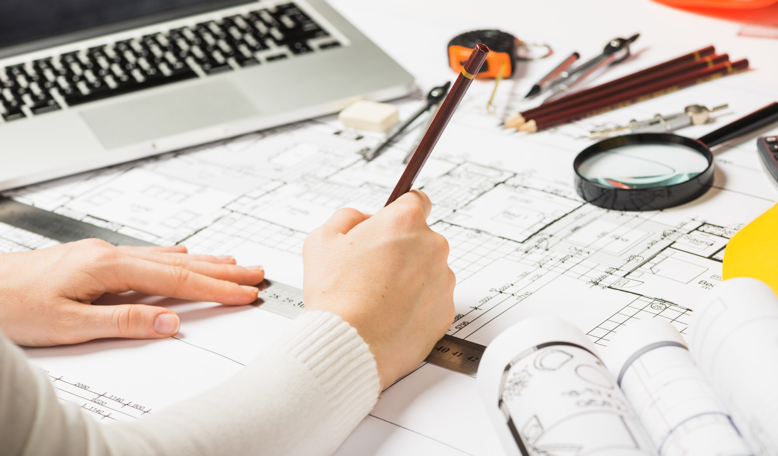 architect-drawing-blueprint-with-pencil